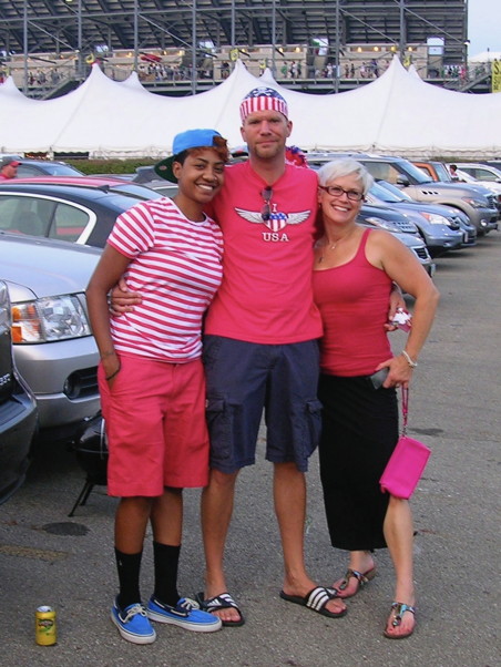 Three people in USA colors standing in a stadium parking lot