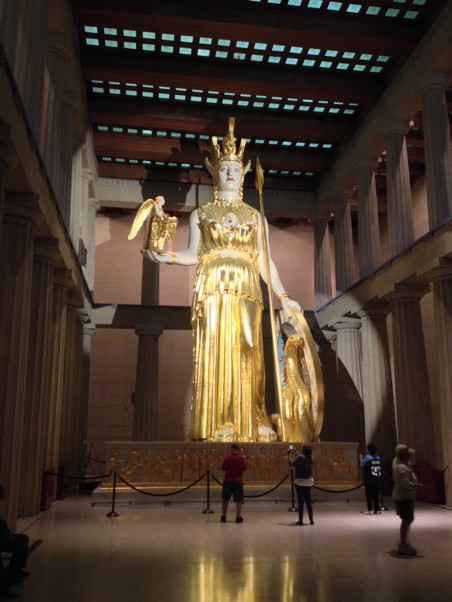 A huge, huge, huge statue of a goddess warrior in gold holding a shield