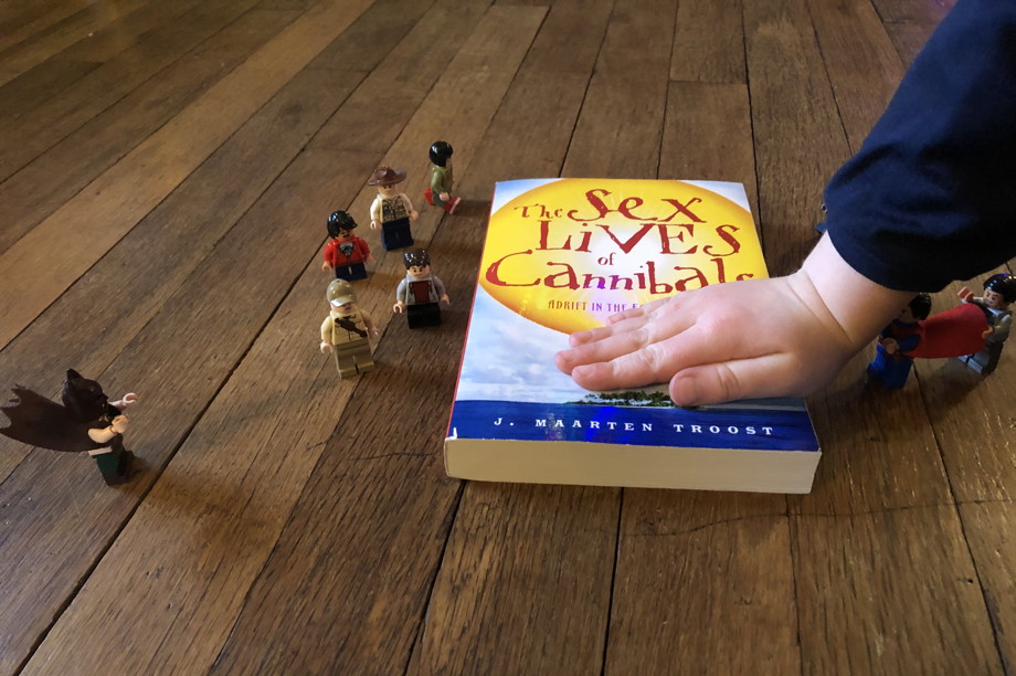 A book, with Francis's hand on it, surrounded by Jurassic Park Lego characters