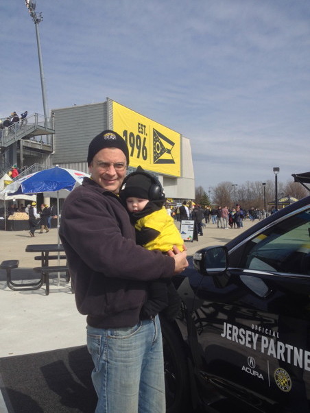 Me holding Francis at MAPFRE Stadium in front of a "Est. 1996" banner