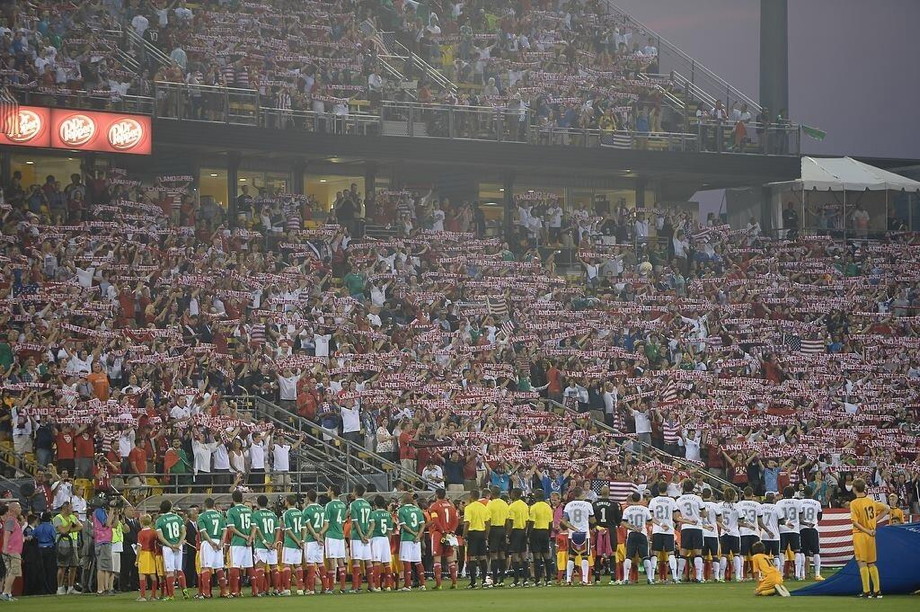 Two teams facing a crowd showing USA scarves