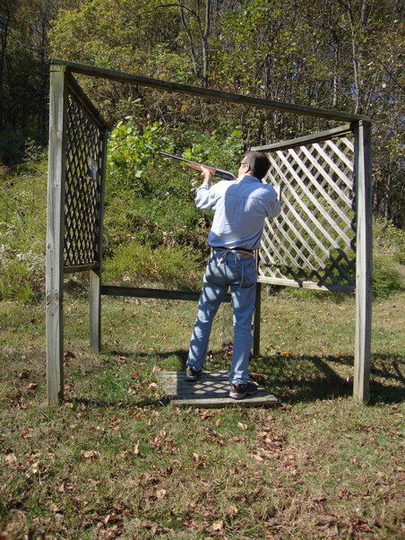 Me at a stand, shooting clays with a shotgun