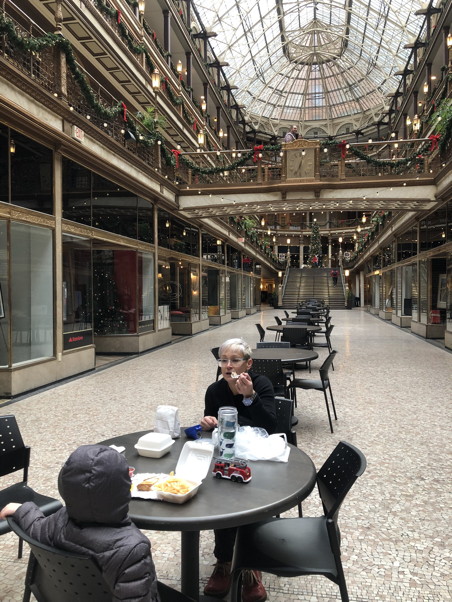 Gina anf Francis at a table in an empty, gilded department store