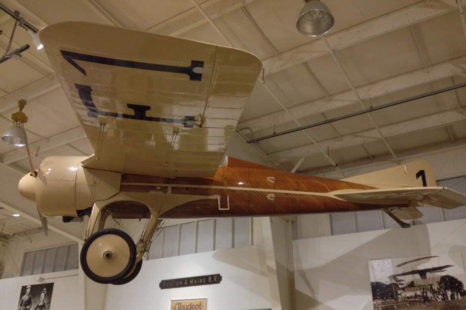 A small brown and beige airplane hanging from the ceiling