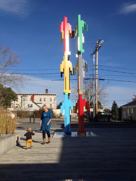 Mother and son in a plaza next to a colorful sculpture of video game characters