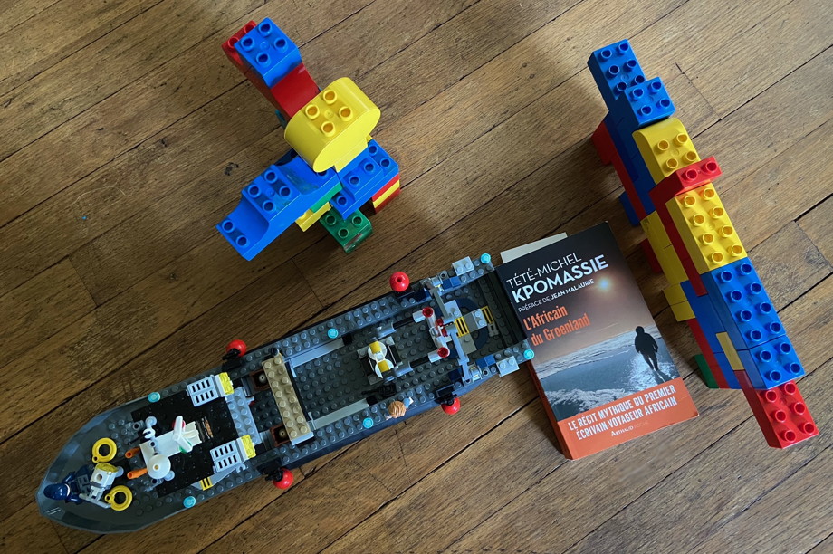The book surrounded by a Lego boat, wall, and large robot