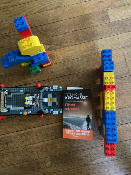 The book surrounded by a Lego boat, wall, and large robot
